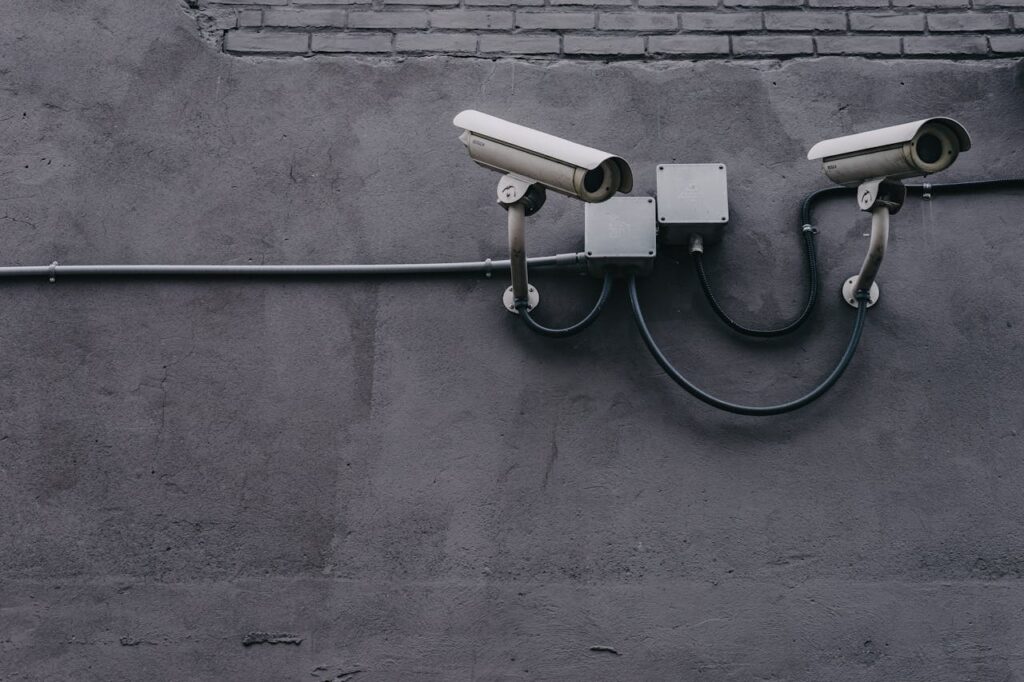 pexels-photo-430208 Two surveillance cameras mounted on a concrete wall, highlighting security technology.